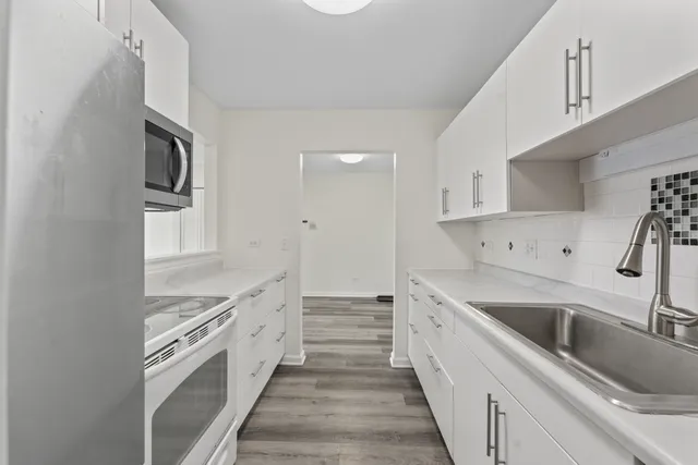 a large kitchen with a sink and cabinets
