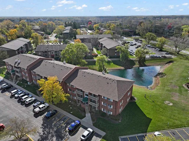 an aerial view of a house with a yard lake outdoor space and mountain view