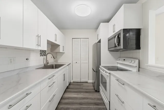 a kitchen with a sink stove and cabinets