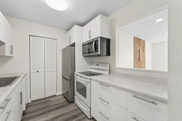 a kitchen with stainless steel appliances a stove microwave and refrigerator