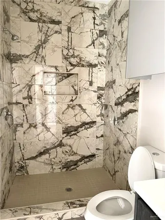 a white toilet sitting next to a shower