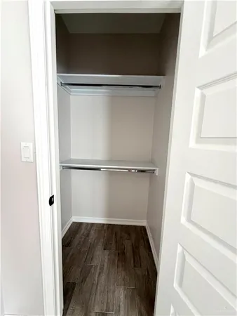 a view of walk in closet with wooden floor