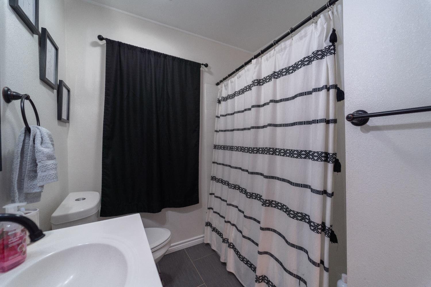 1517 41st Street Lubbock, TX 79412 - Photo 13 of 22 a bathroom with a sink and a shower
