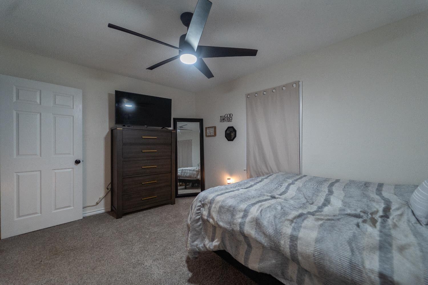 1517 41st Street Lubbock, TX 79412 - Photo 14 of 22 a bedroom with a bed and a ceiling fan