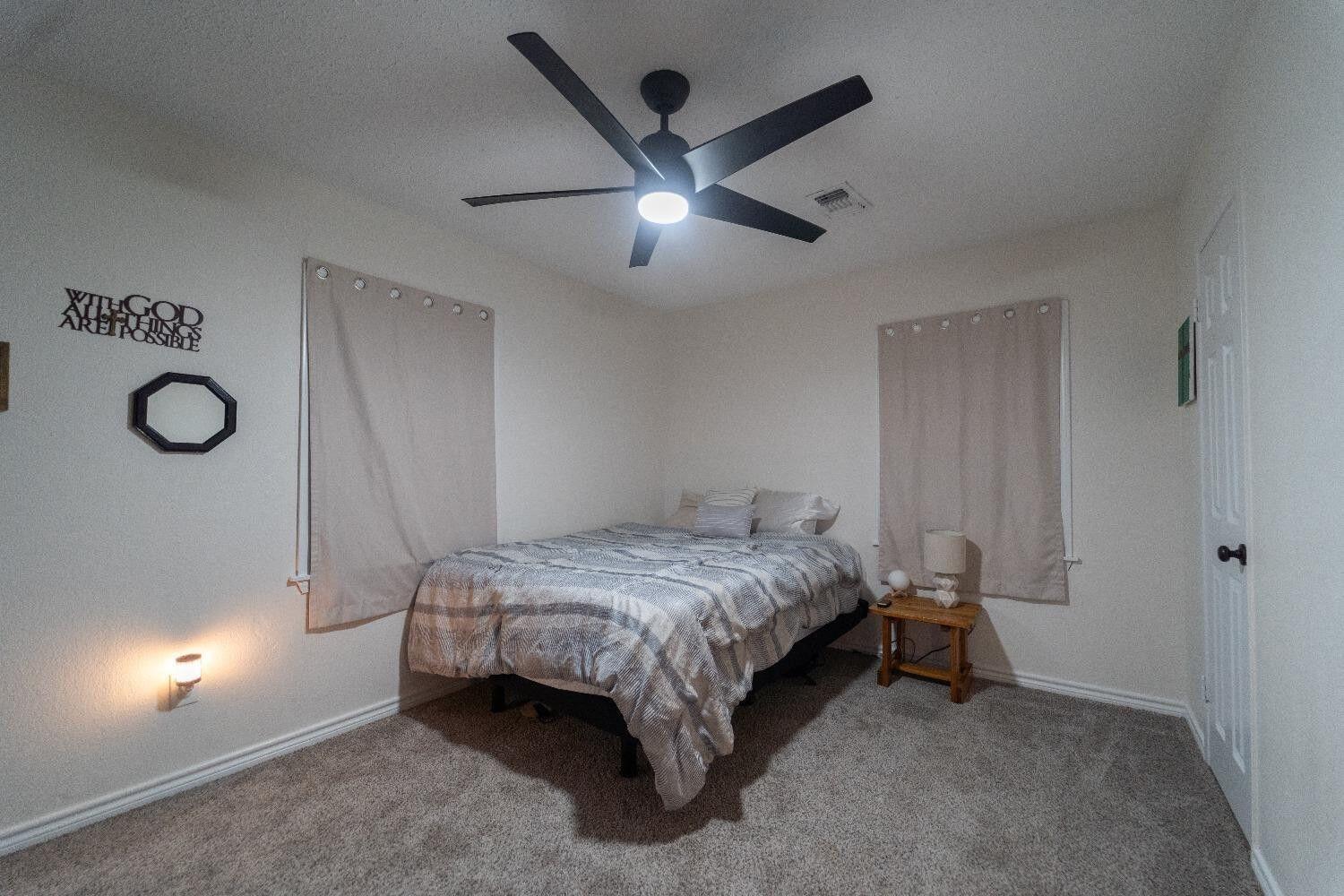 1517 41st Street Lubbock, TX 79412 - Photo 15 of 22 a bed room with a bed and a ceiling fan