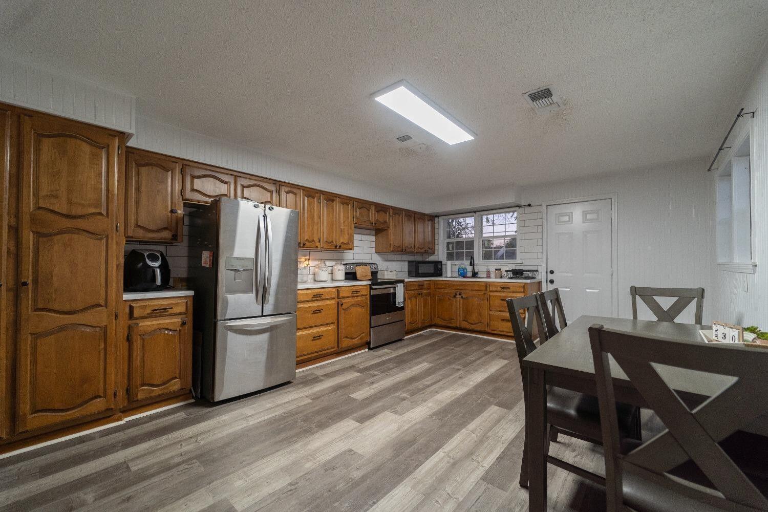 1517 41st Street Lubbock, TX 79412 - Photo 5 of 22 a kitchen with refrigerator cabinets table and chairs