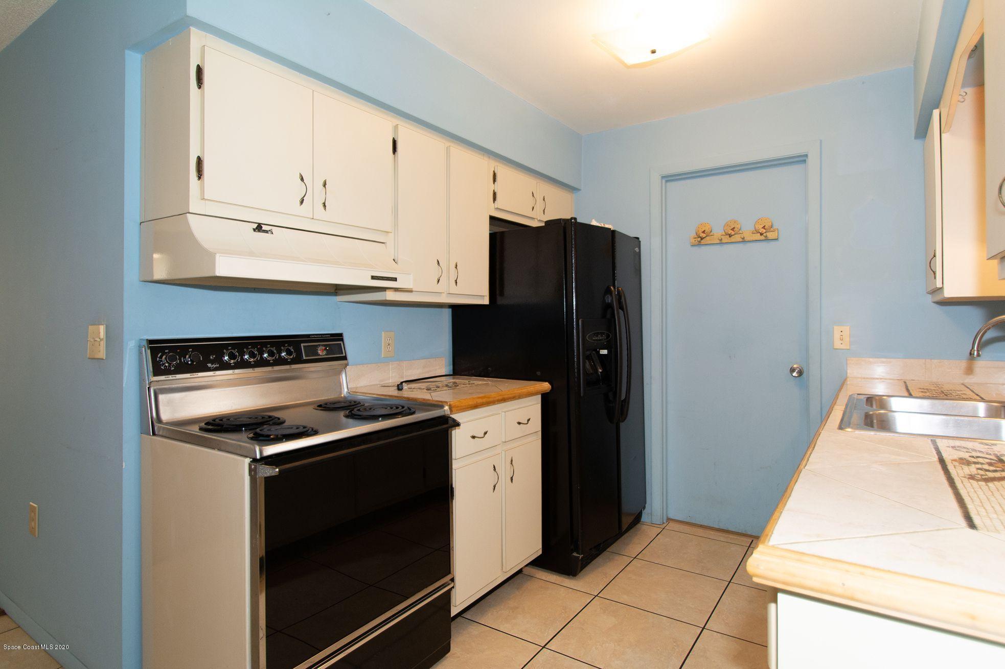 2872 Pembroke Road Melbourne, FL 32935 - Photo 12 of 32 a kitchen with granite countertop cabinets and steel stainless steel appliances