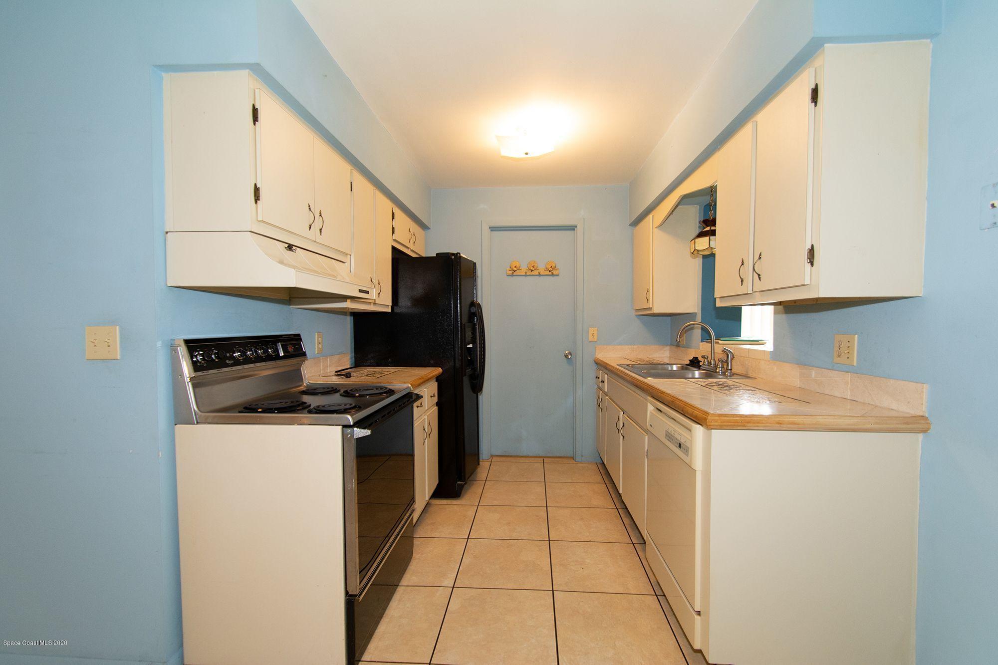 2872 Pembroke Road Melbourne, FL 32935 - Photo 13 of 32 a kitchen with stainless steel appliances granite countertop a stove a sink and a refrigerator