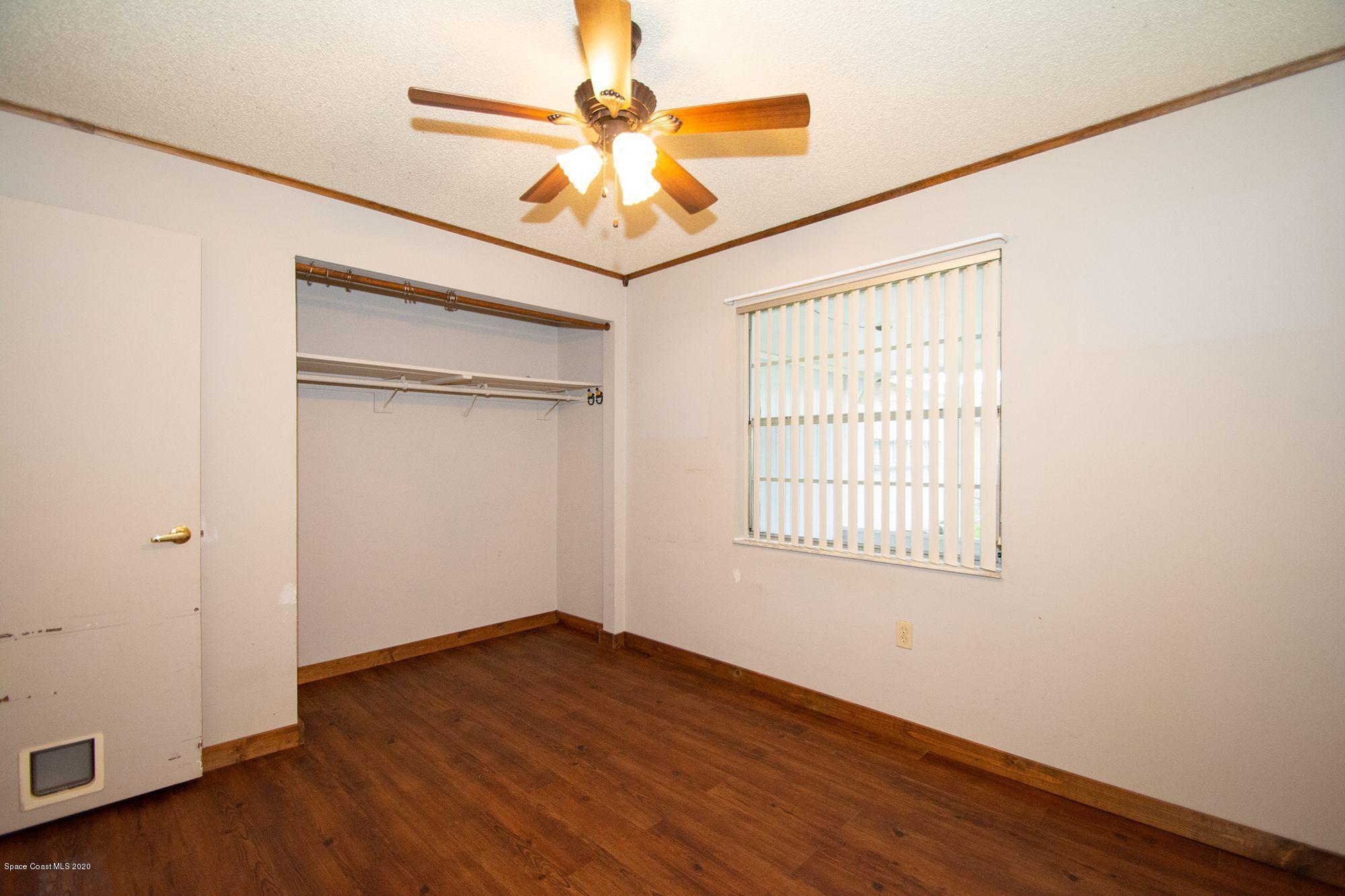 2872 Pembroke Road Melbourne, FL 32935 - Photo 25 of 32 an empty room with wooden floor fan and windows