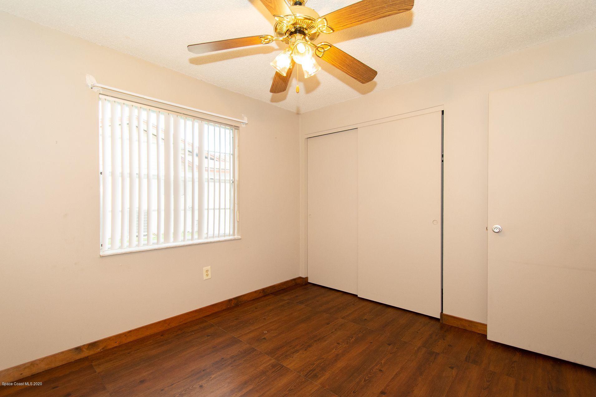 2872 Pembroke Road Melbourne, FL 32935 - Photo 27 of 32 an empty room with wooden floor fan and windows