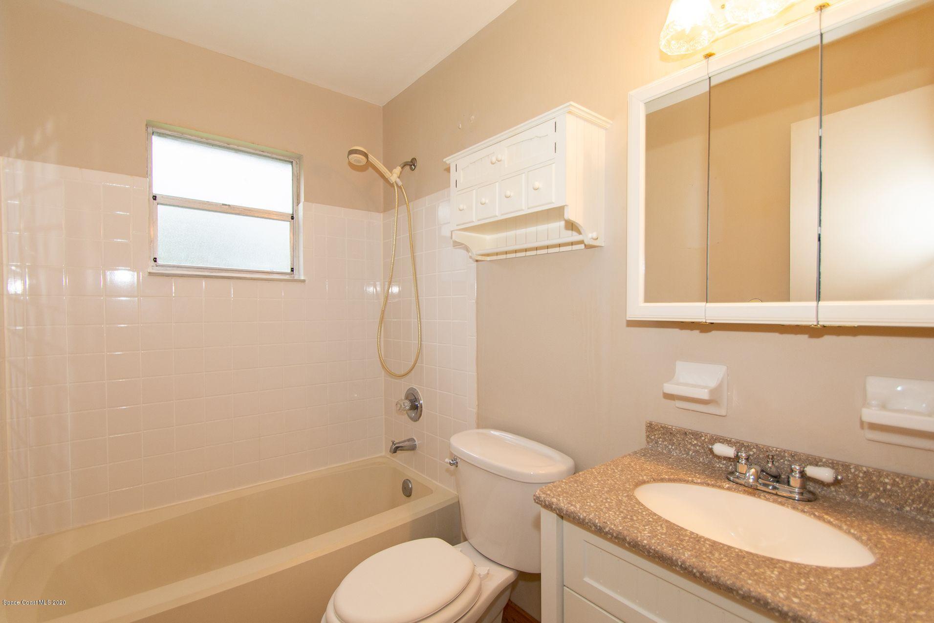2872 Pembroke Road Melbourne, FL 32935 - Photo 28 of 32 a bathroom with a granite countertop sink toilet and shower
