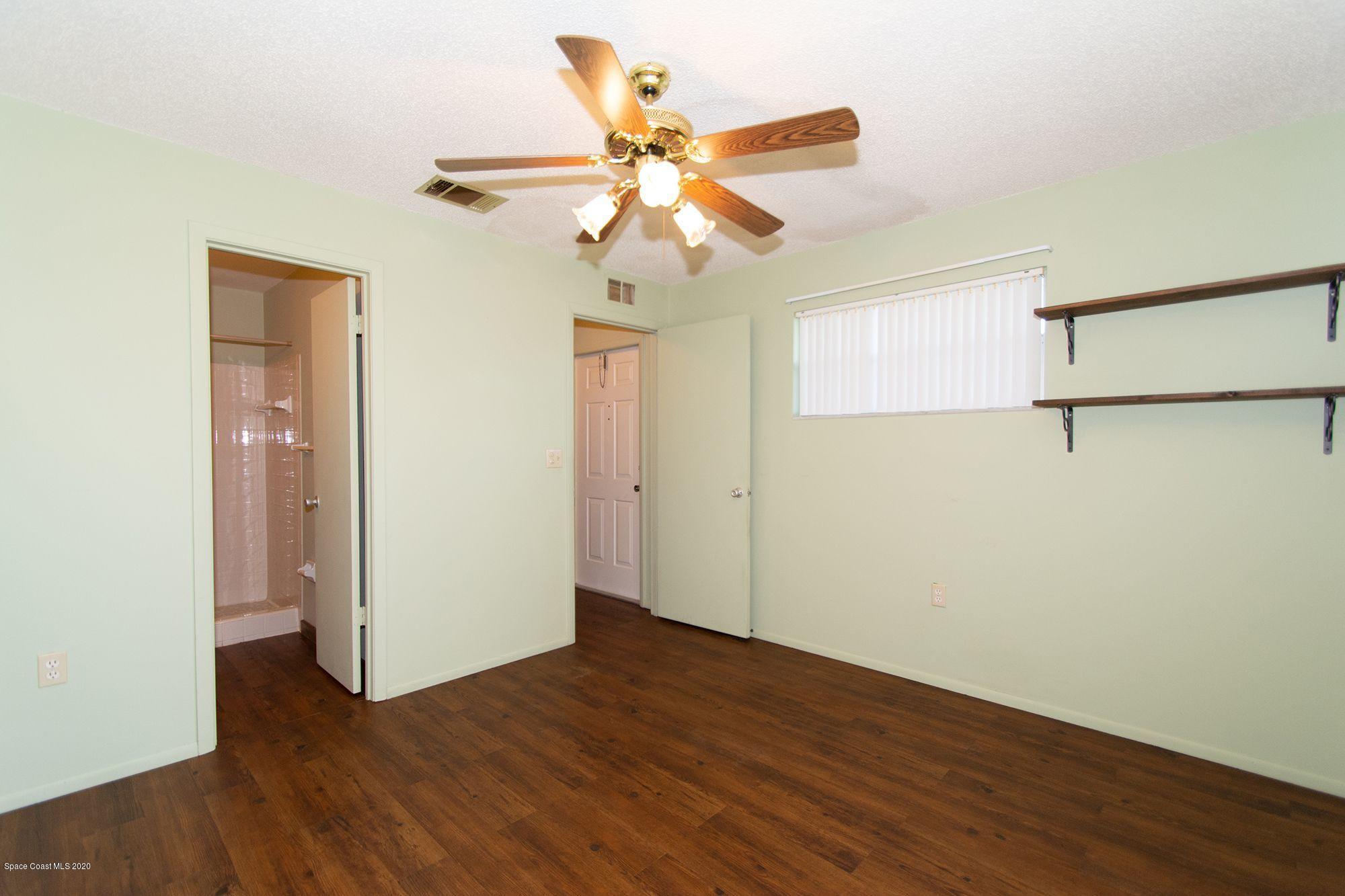2872 Pembroke Road Melbourne, FL 32935 - Photo 30 of 32 a view of an empty room with wooden floor and a ceiling fan