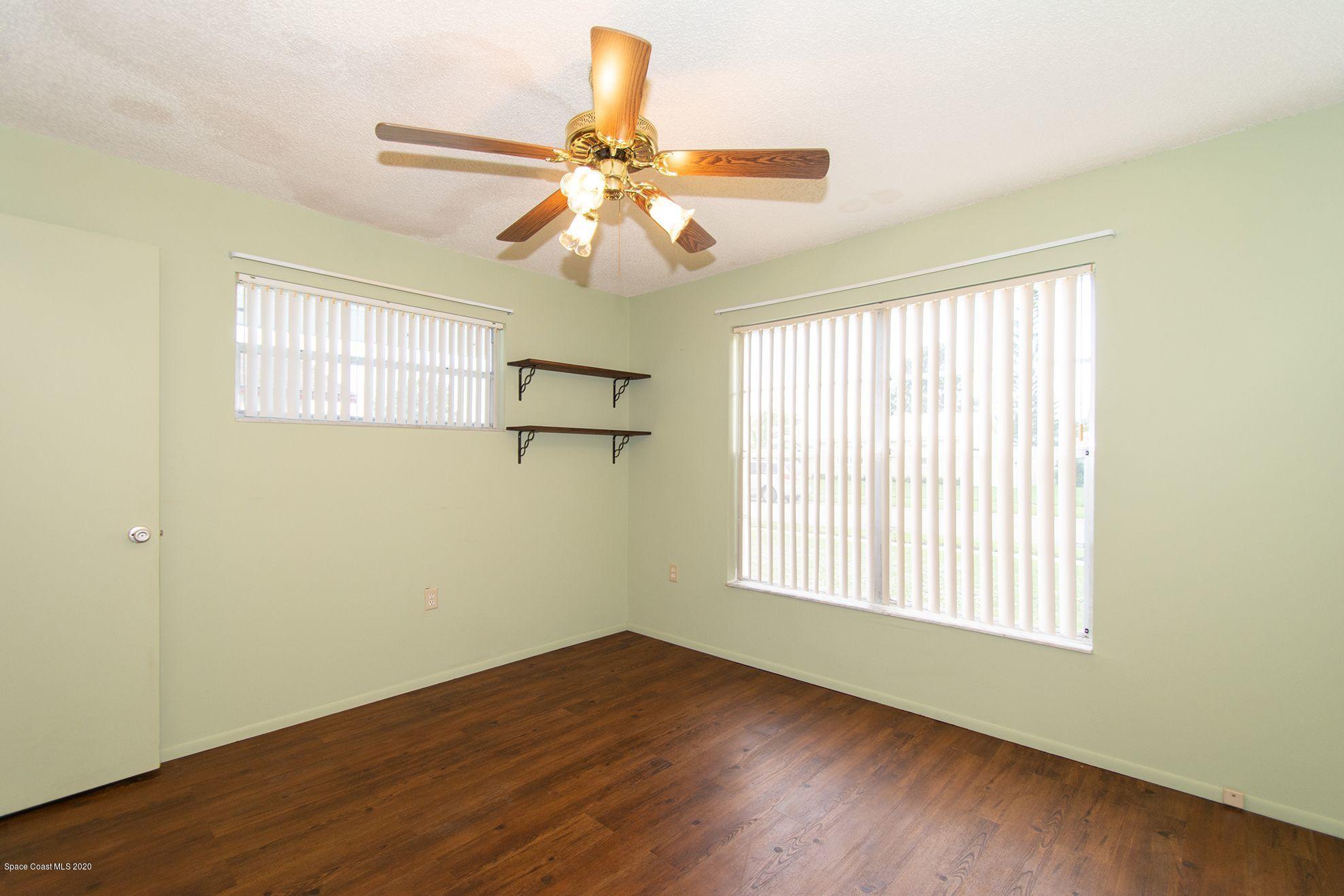 2872 Pembroke Road Melbourne, FL 32935 - Photo 31 of 32 a view of an empty room with wooden floor and a window