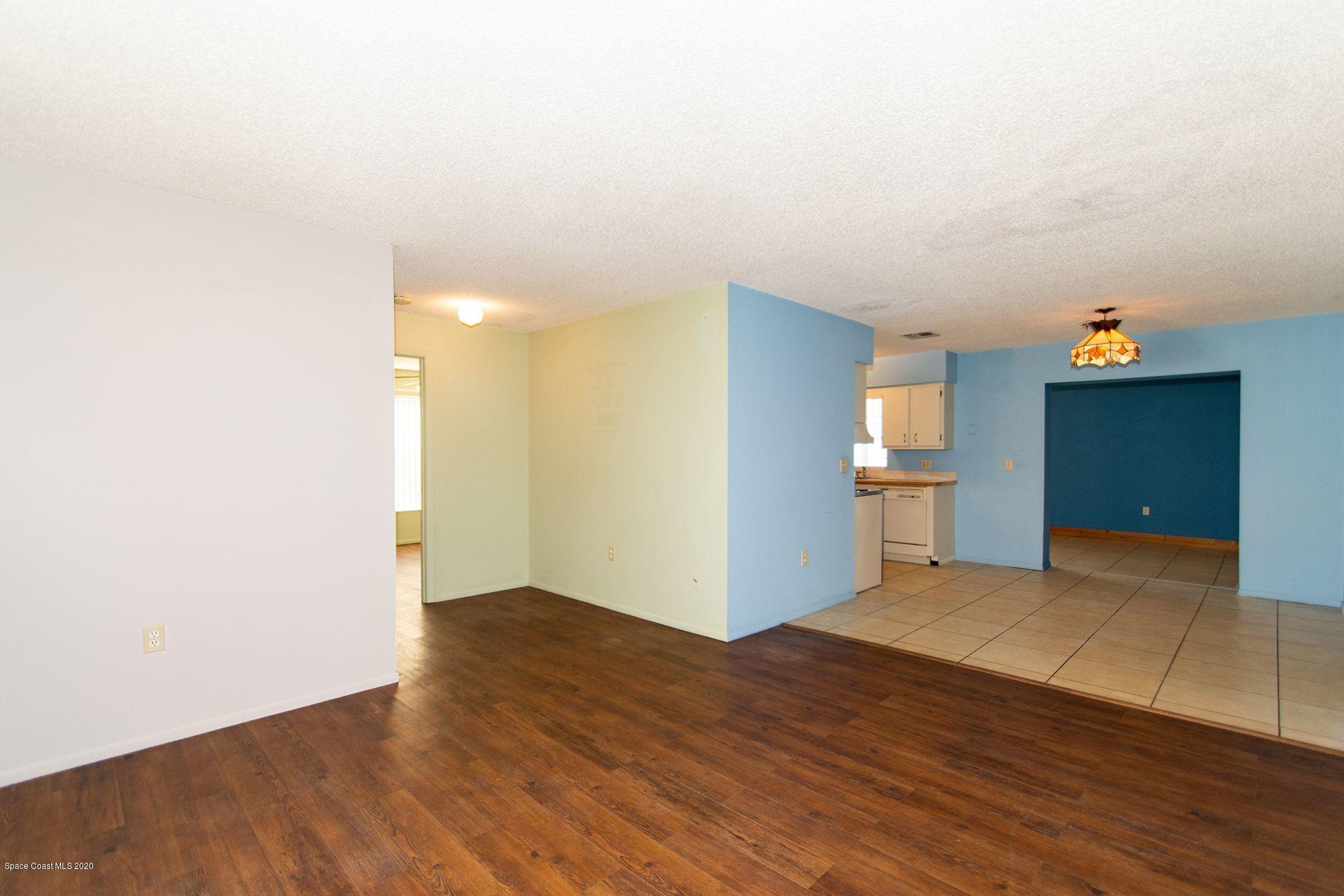 2872 Pembroke Road Melbourne, FL 32935 - Photo 7 of 32 a view of a kitchen with wooden floor and a refrigerator