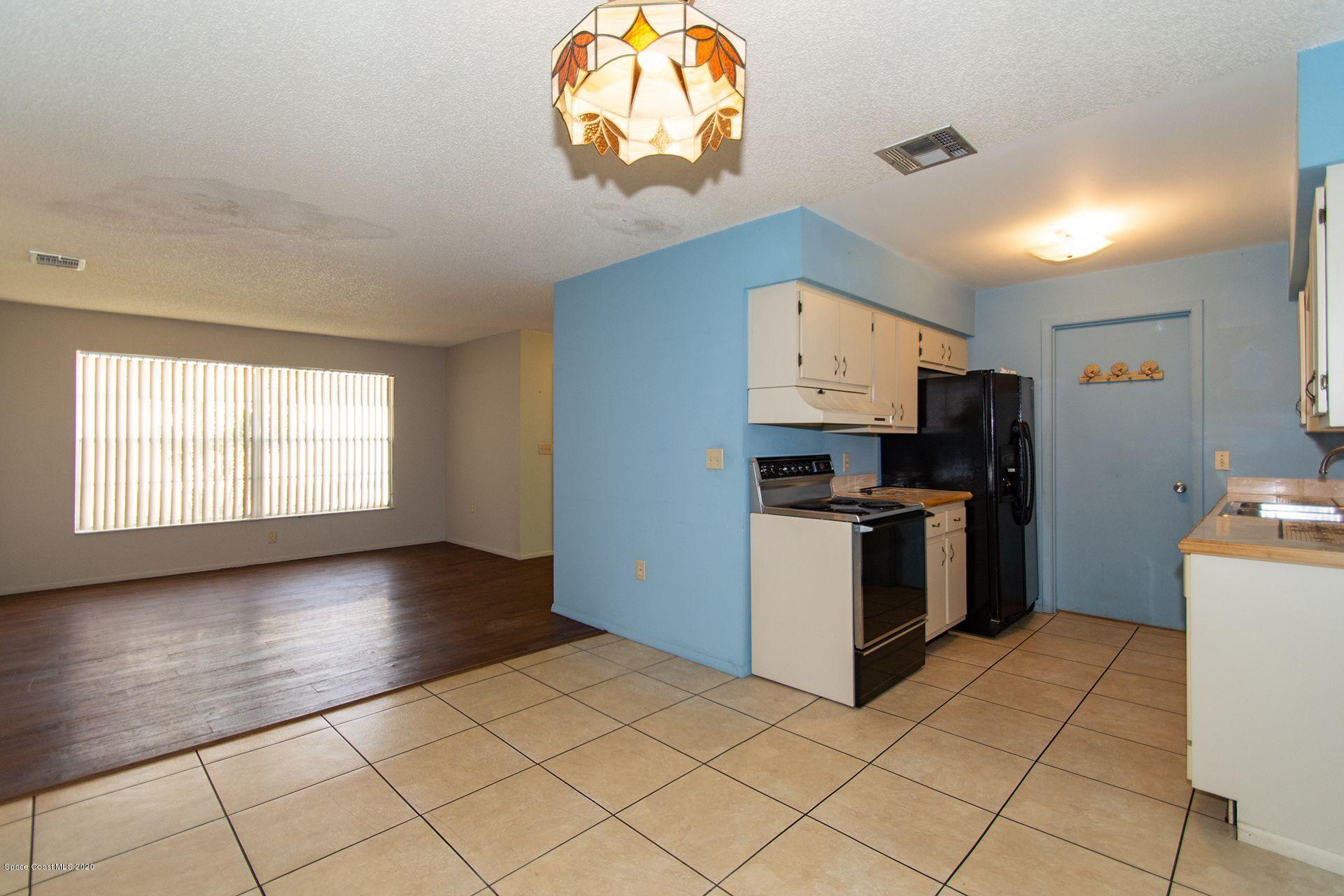 2872 Pembroke Road Melbourne, FL 32935 - Photo 8 of 32 a kitchen with stainless steel appliances granite countertop a stove a sink and a refrigerator