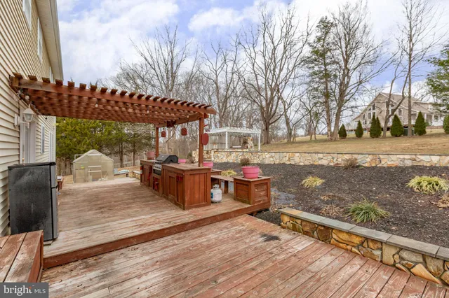 a view of a patio with table and chairs a barbeque with wooden floor and fence