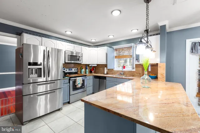 a kitchen with kitchen island a counter top space stainless steel appliances and cabinets