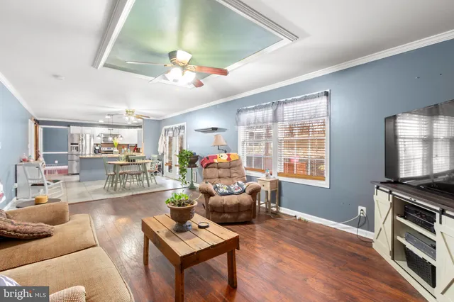 a living room with furniture a flat screen tv and a window