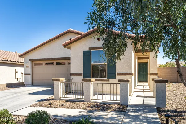 a front view of a house with a tree
