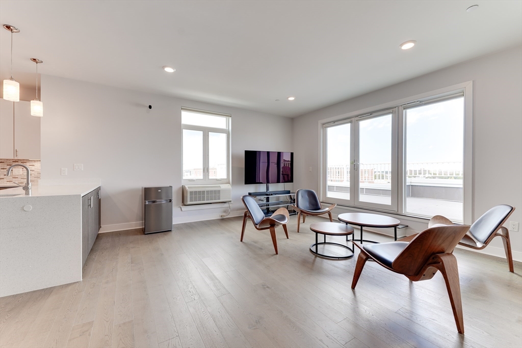 2 Cliveden Street, Unit 601E Quincy, MA 02169 - Photo 11 of 27 a living room with furniture and a flat screen tv