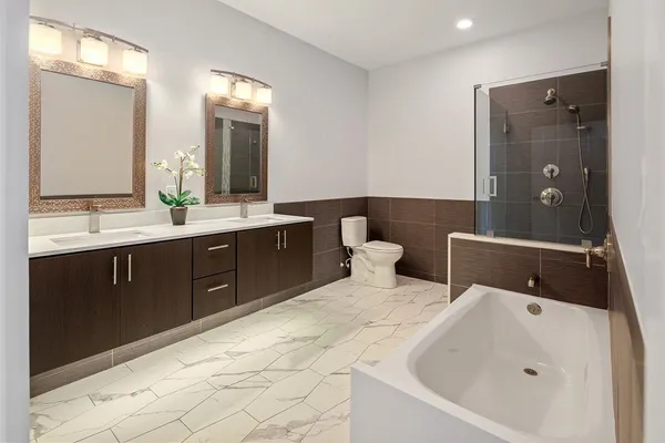a spacious bathroom with a bathtub sink and mirror