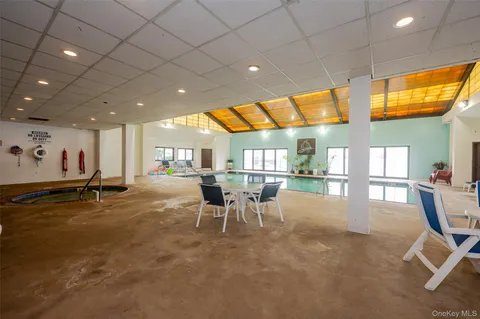 a dining hall with stainless steel appliances a dining table and chairs with the view of kitchen