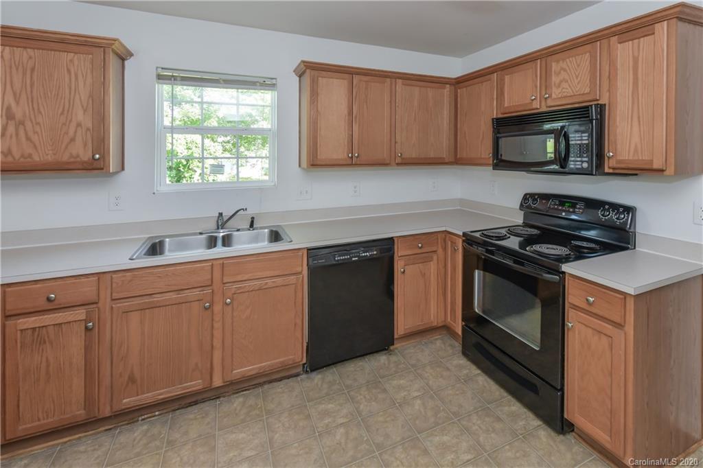 3906 Harris Houston Road Charlotte, NC 28262 - Photo 14 of 28 a kitchen with stainless steel appliances granite countertop white cabinets a sink a stove and a microwave