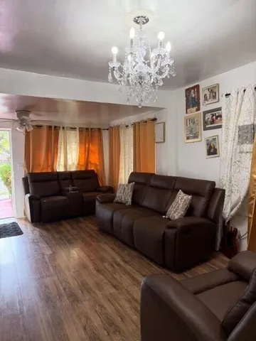 a living room with furniture and a chandelier