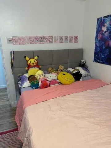 a bedroom with a bed and teddy bear on bed
