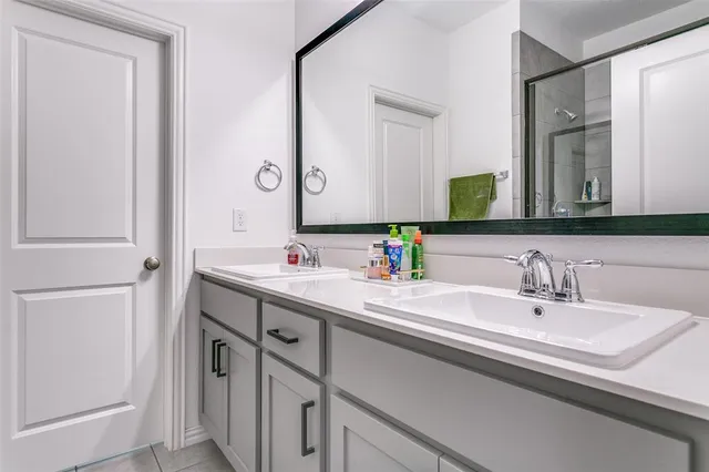 a bathroom with a double vanity sink and a mirror