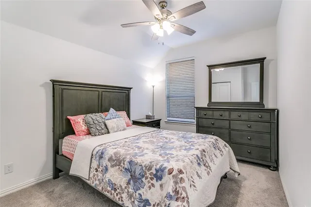 a bedroom with a bed and a mirror on dresser