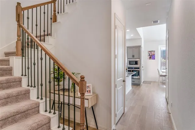 a view of staircase with wooden floor and a rug