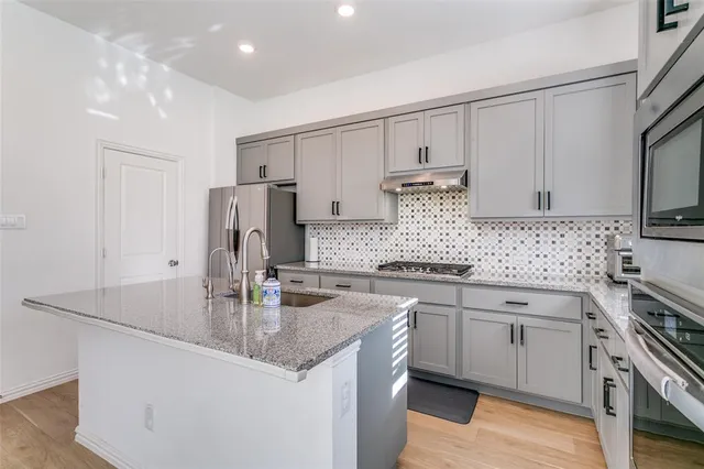 a kitchen with stainless steel appliances granite countertop a sink stove and refrigerator