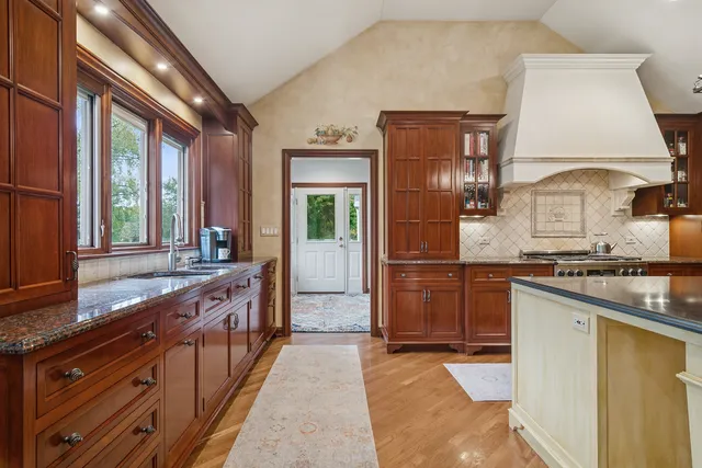a kitchen with stainless steel appliances granite countertop a sink stove and cabinets