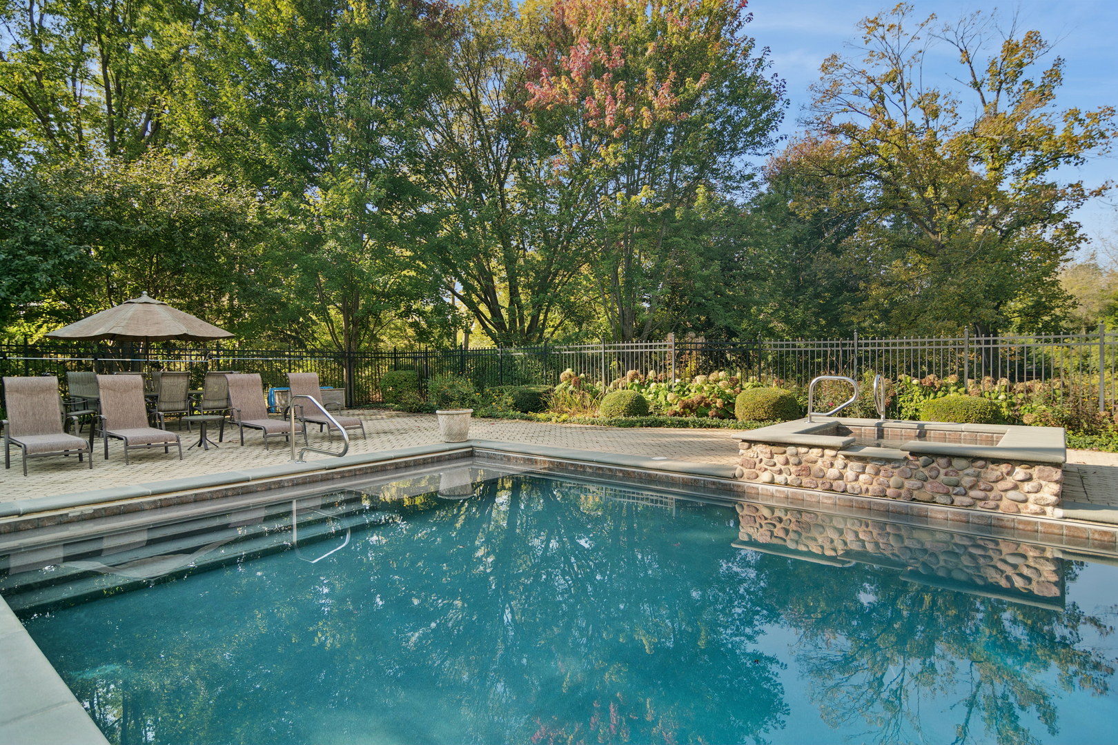 1987 Selkirk Court Inverness, IL 60010 - Photo 48 of 63 a view of a swimming pool with a table and chairs under an umbrella