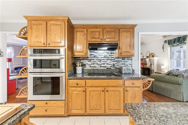 a kitchen with stainless steel appliances granite countertop a sink stove and cabinets