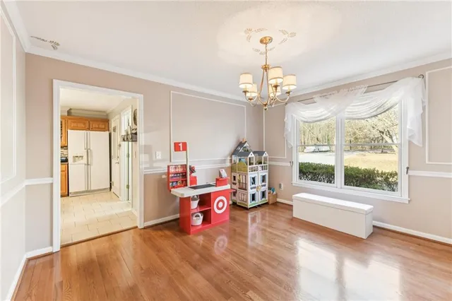 a spacious bedroom with a bed next to a window and a chandelier