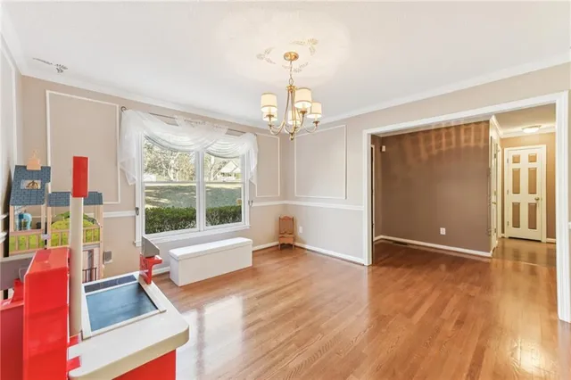 a spacious bedroom with a bed and a chandelier