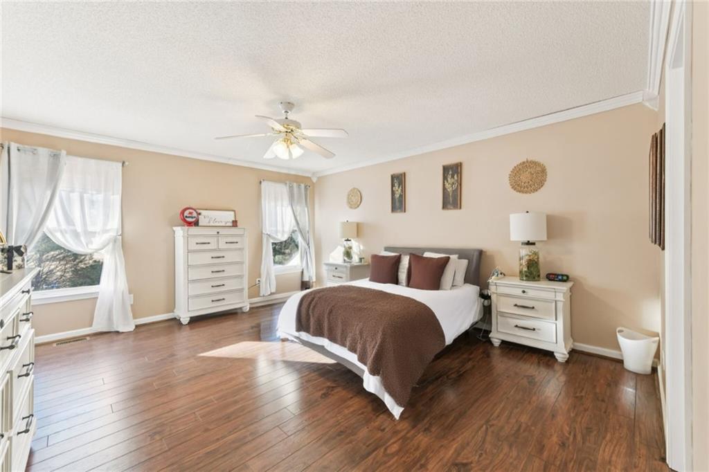 3415 South View Trail Gainesville, GA 30506 - Photo 22 of 65 a spacious bedroom with a bed next to a window and a chandelier