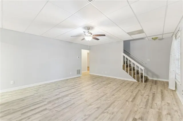 an empty room with a chandelier fan and ceiling fan