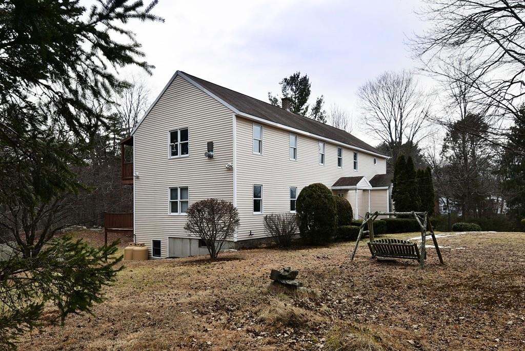 a view of a house with backyard and a tree