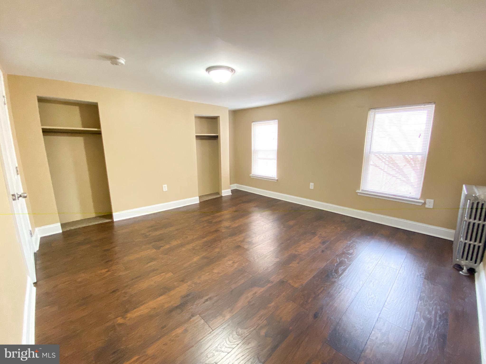 174 Master Street Philadelphia, PA 19122 - Photo 11 of 12 an empty room with wooden floor and windows