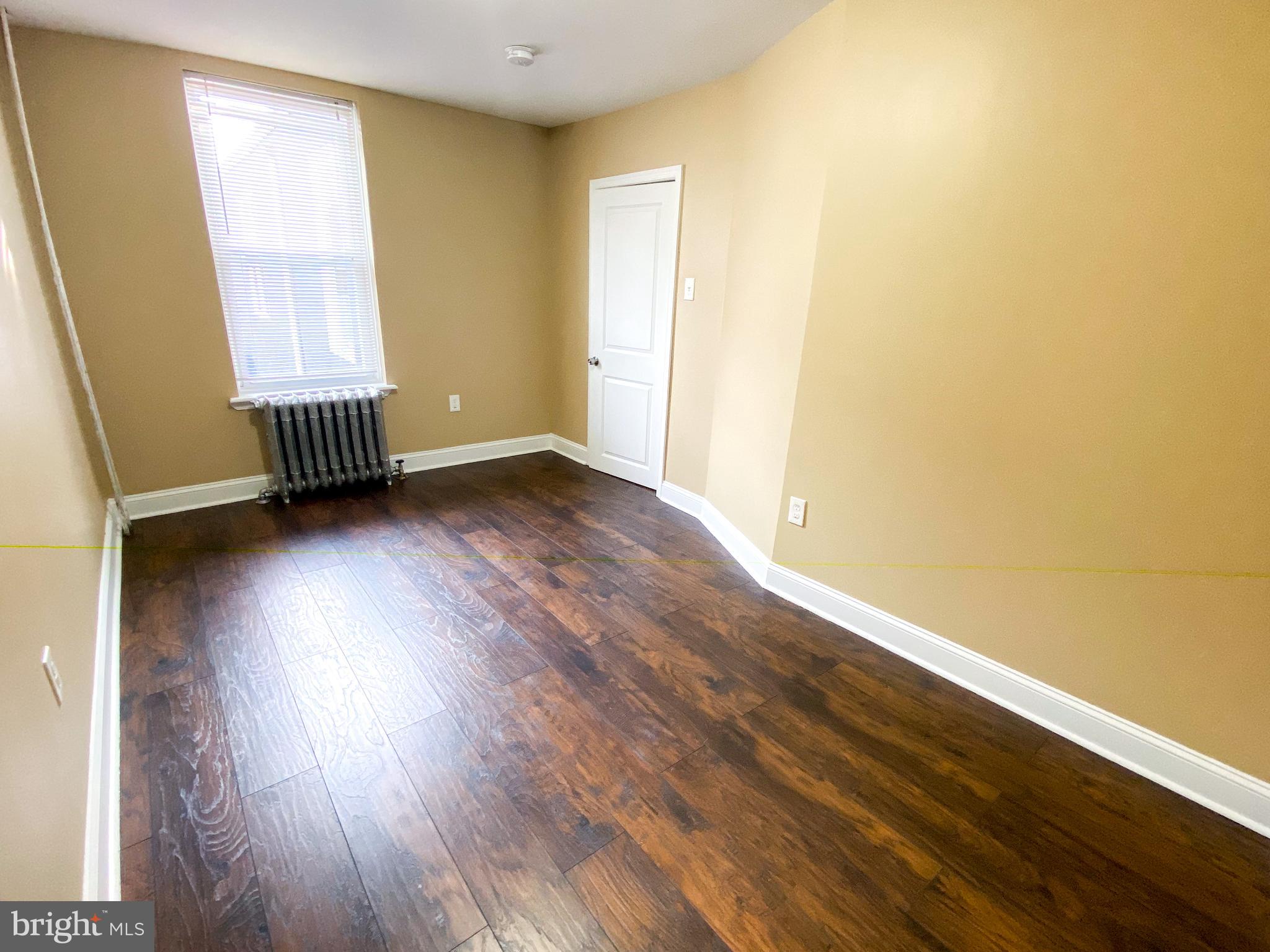 174 Master Street Philadelphia, PA 19122 - Photo 6 of 12 an empty room with wooden floor and windows