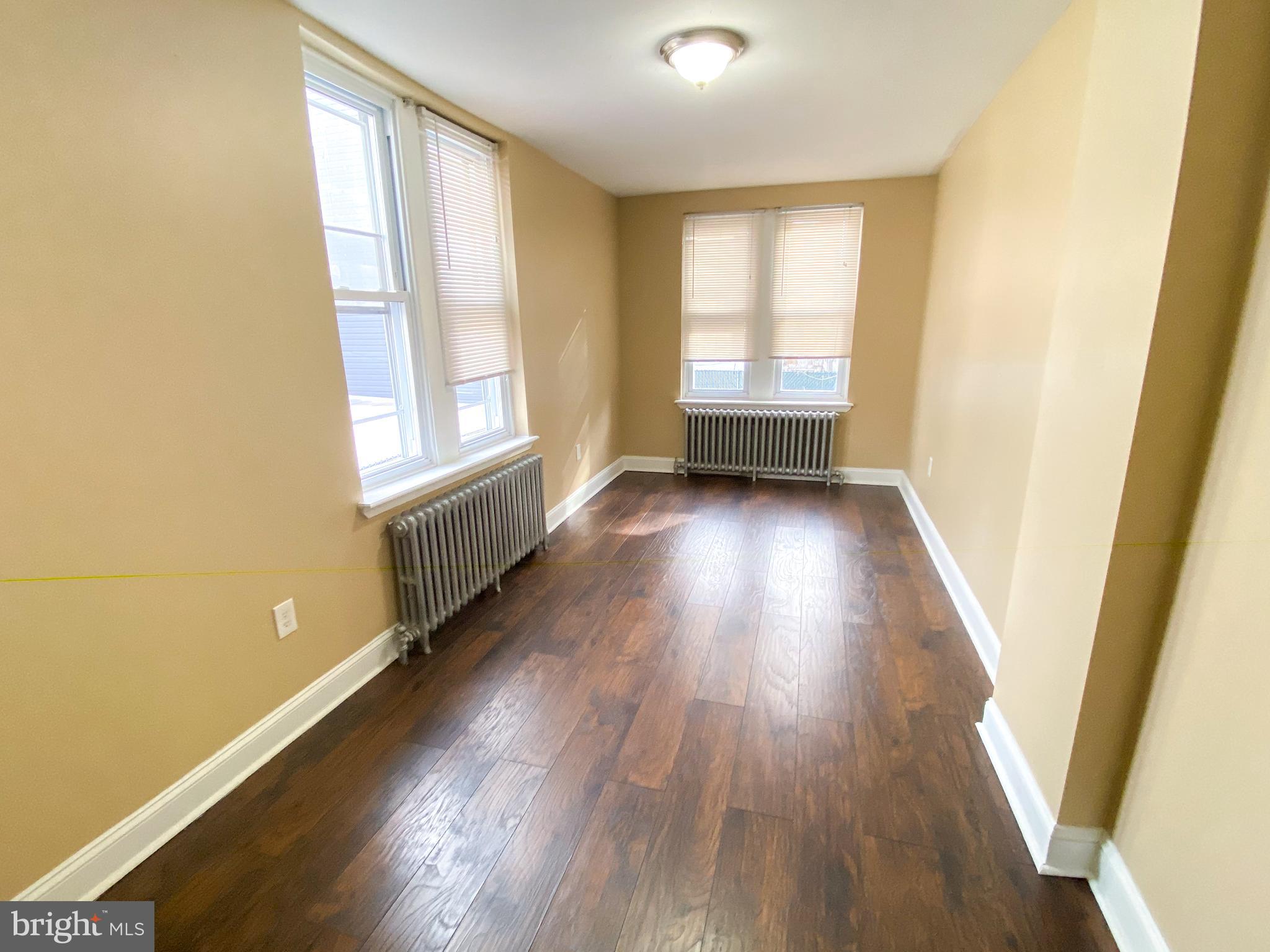174 Master Street Philadelphia, PA 19122 - Photo 8 of 12 an empty room with wooden floor and windows
