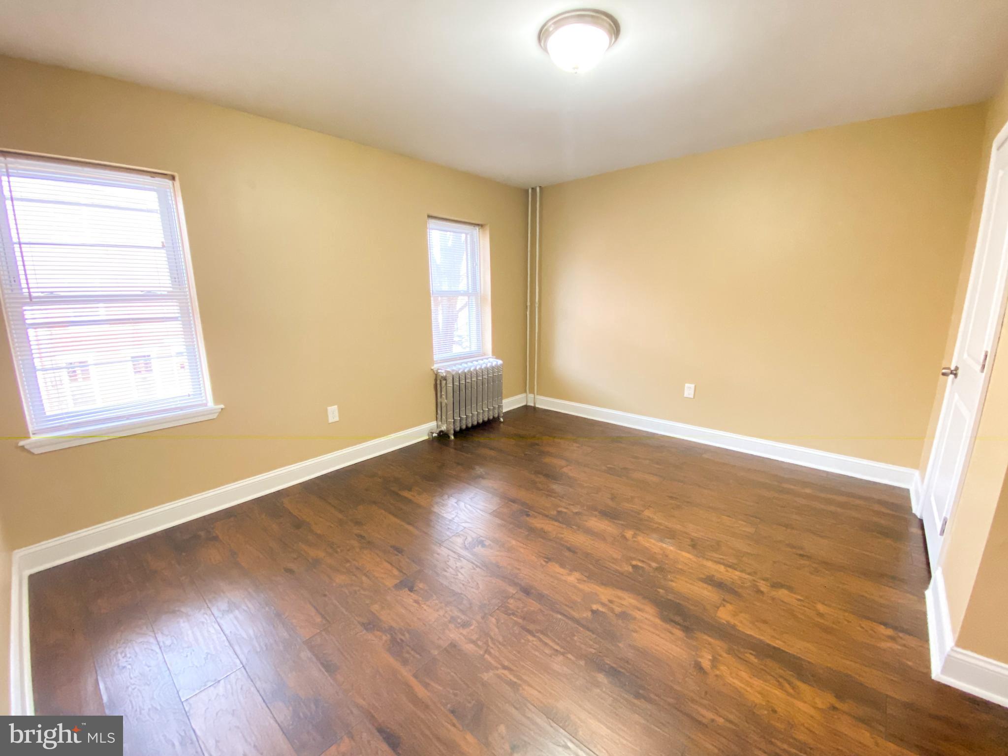 174 Master Street Philadelphia, PA 19122 - Photo 9 of 12 an empty room with wooden floor and windows
