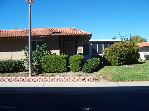 a view of a house with a small yard and potted plants