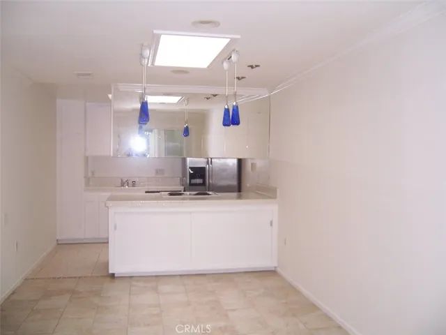 a view with kitchen island with stainless steel appliances a sink and a window