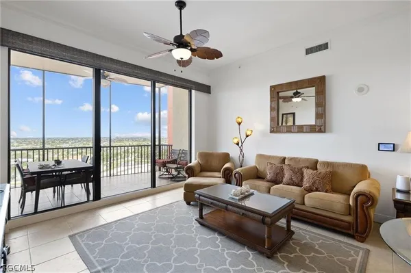 a living room with furniture kitchen view and a chandelier