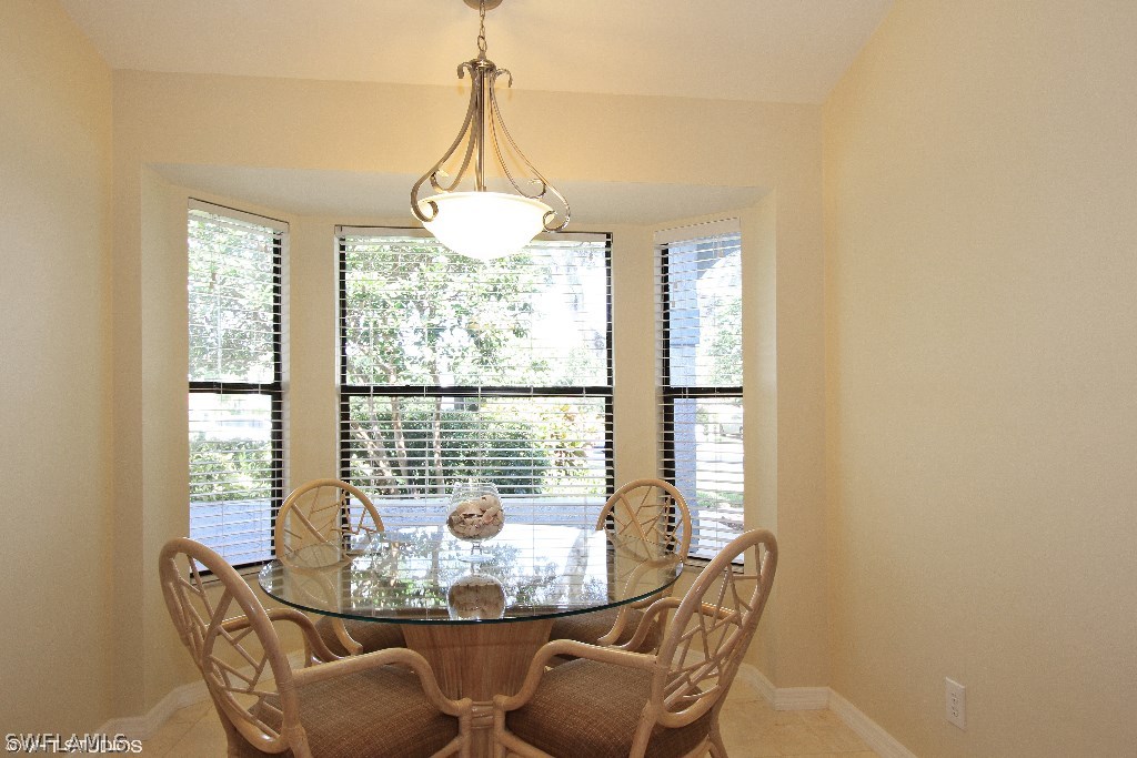 13266 Heather Ridge Loop Fort Myers, FL 33966 - Photo 5 of 12 a dining room with furniture a chandelier and wooden floor