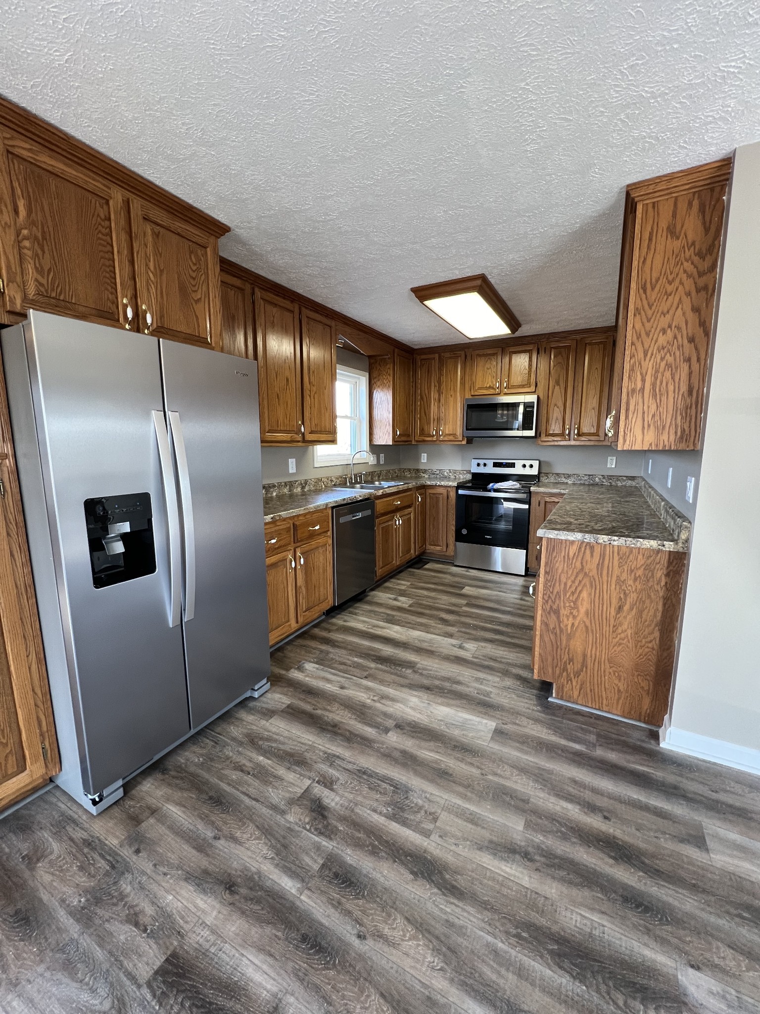 1109 W Road Red Boiling Springs, TN 37150 - Photo 4 of 14 a kitchen with stainless steel appliances granite countertop a refrigerator a stove top oven a sink and dishwasher